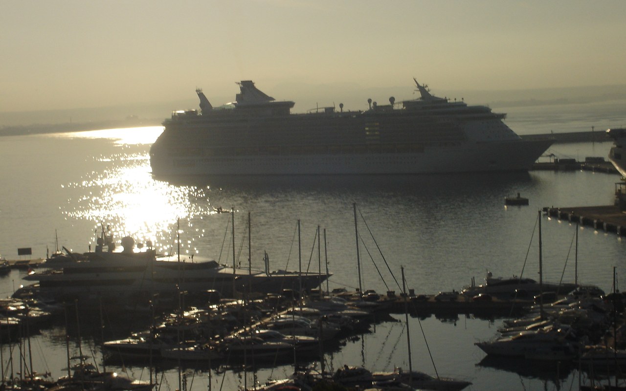 Cruise ship moored beside a Mediterranean harbour at golden hour