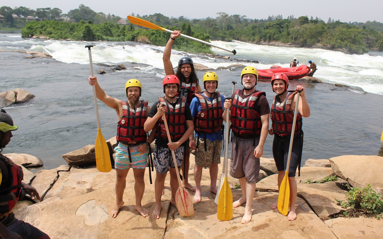 Group of travellers with paddles and life jackets after rafting on the Nile in Uganda